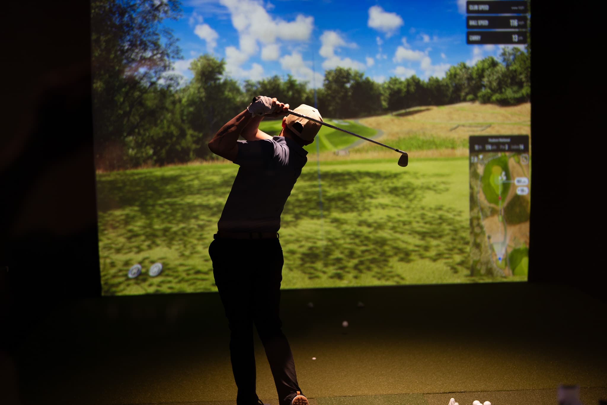 Member swinging in a private golf suite
